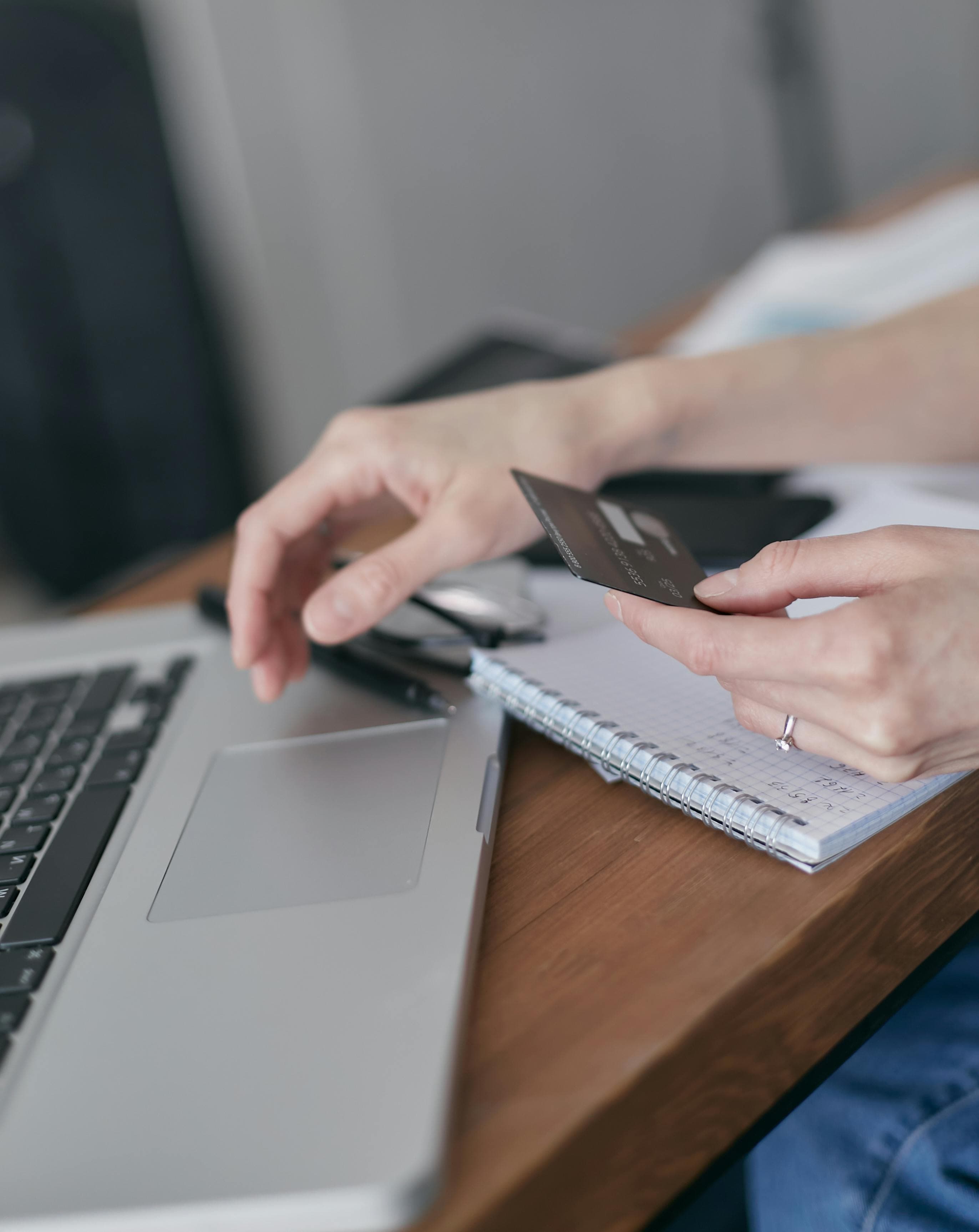 Customer paying by card while booking on a laptop.