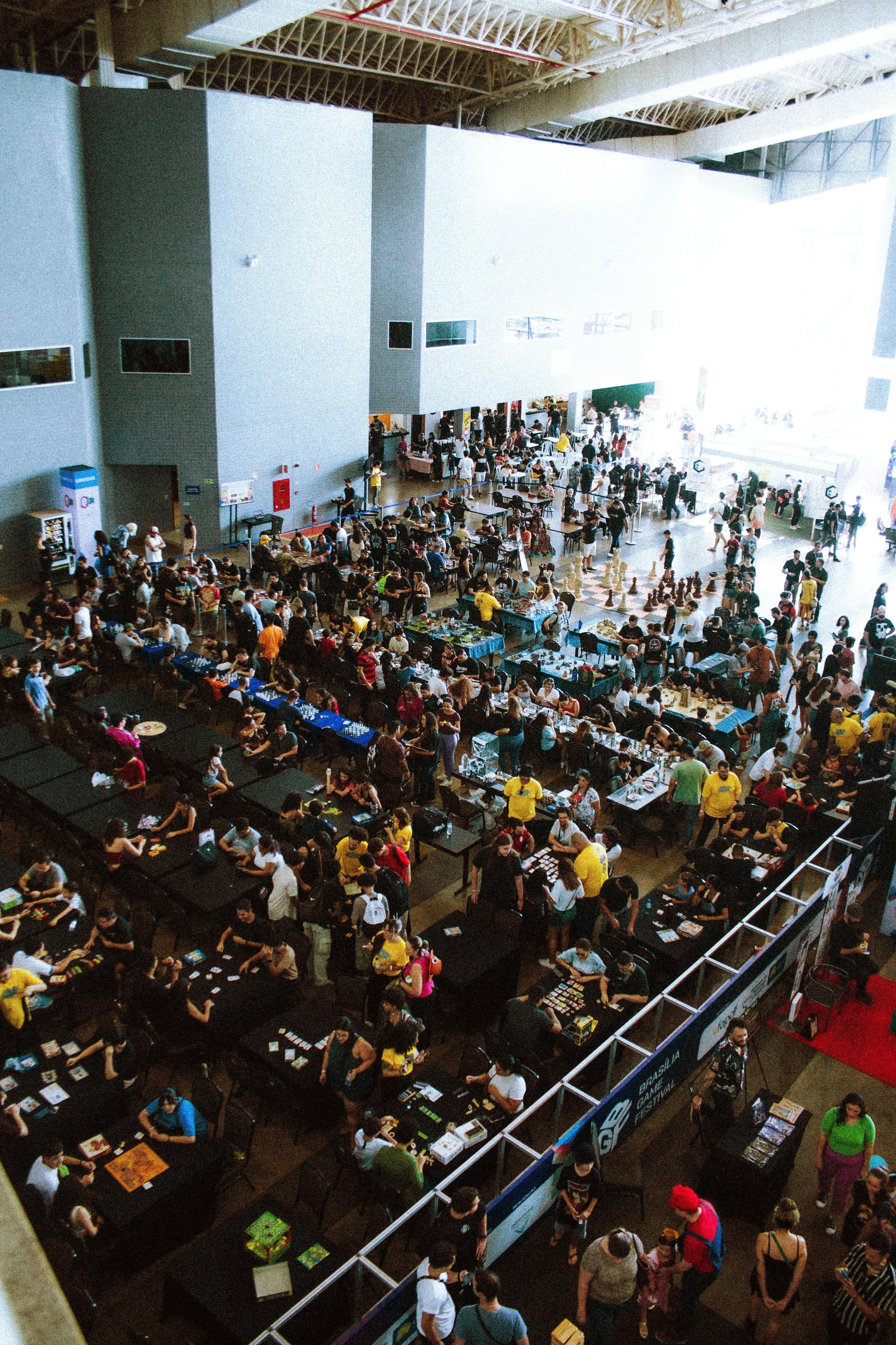 Crowded convention hall with attendees gathered around exhibitor booths.